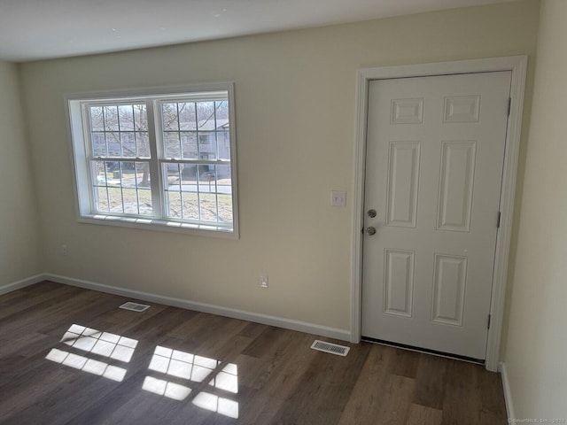 foyer entrance featuring baseboards, wood finished floors, and visible vents