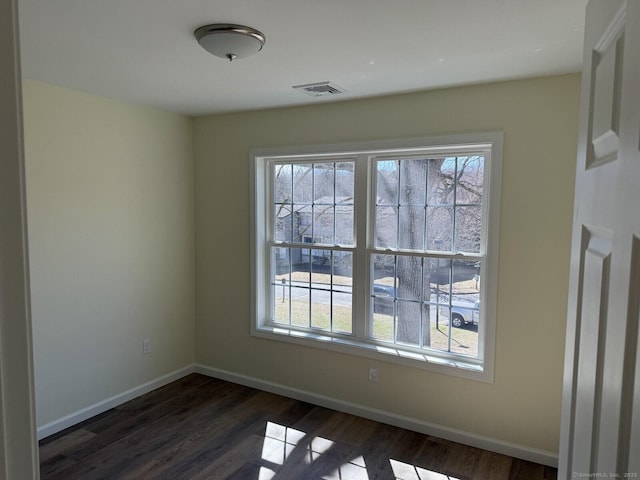 unfurnished dining area featuring dark wood-style flooring, baseboards, visible vents, and a healthy amount of sunlight