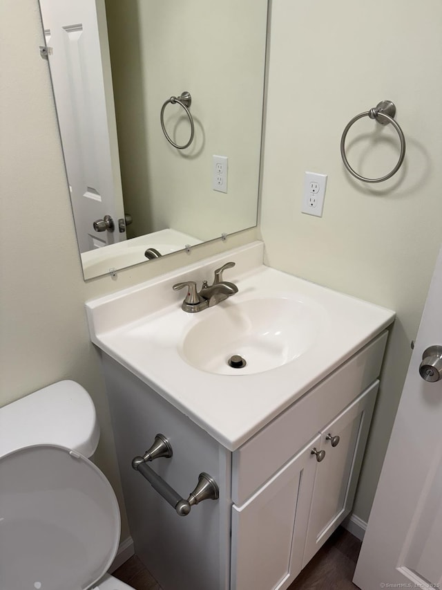 half bathroom featuring vanity and toilet
