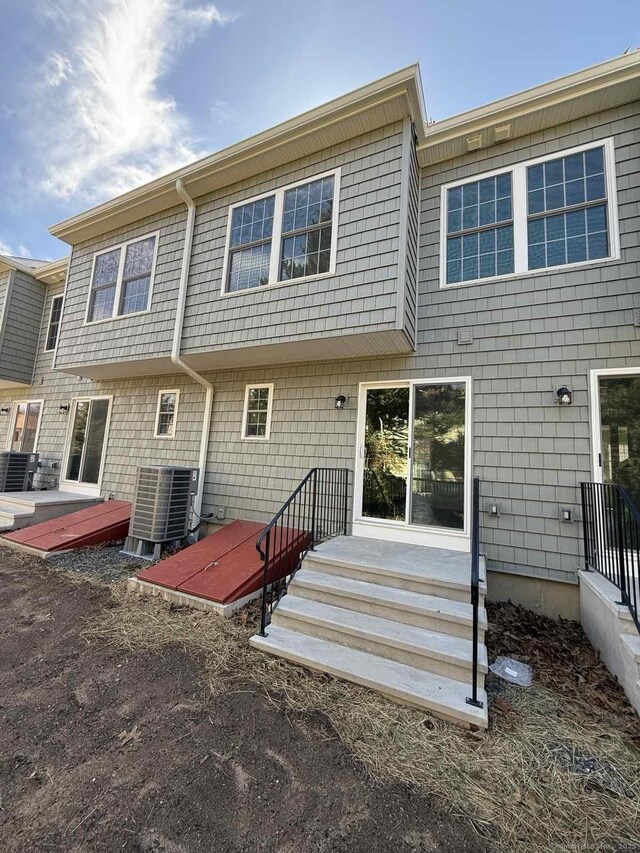 rear view of property with central AC unit and entry steps