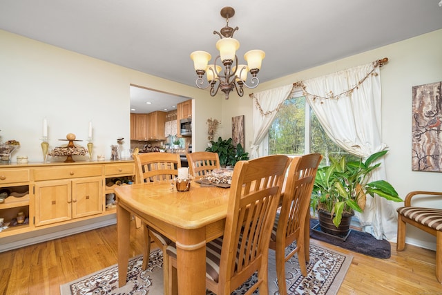 dining room with an inviting chandelier and light wood-type flooring