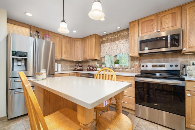 kitchen featuring pendant lighting, light countertops, tasteful backsplash, appliances with stainless steel finishes, and light tile patterned floors