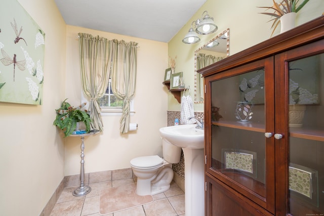 half bath with toilet and tile patterned flooring