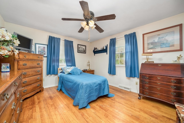 bedroom with baseboards, visible vents, ceiling fan, and light wood-style floors