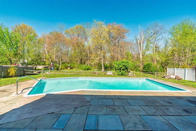 view of swimming pool with a fenced in pool, a fenced backyard, a patio area, and a yard