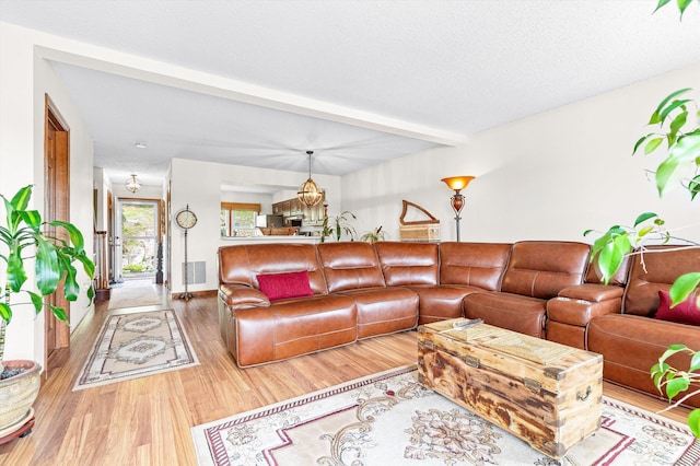 living room with beam ceiling, wood finished floors, and visible vents