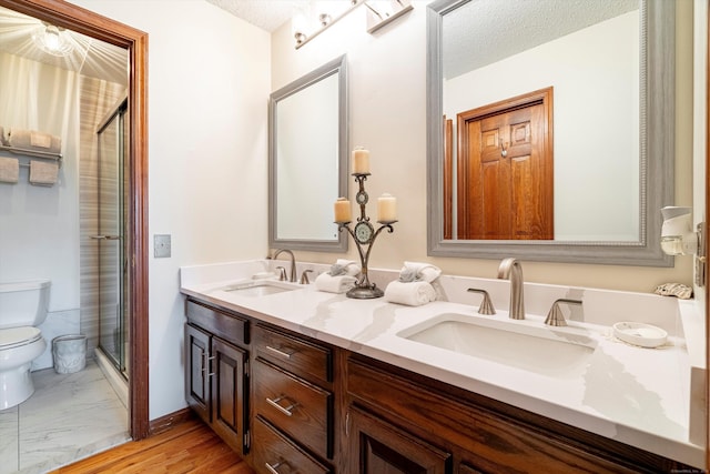 55 Mill Plain Rd Unit 8-1, Danbury, CT 06811 - bathroom featuring a shower stall, double vanity, and a textured ceiling