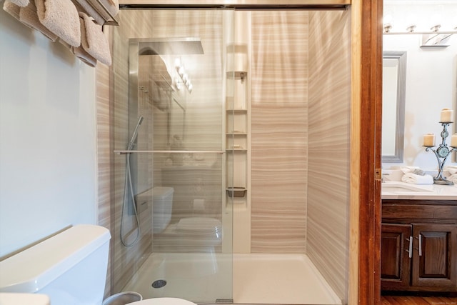 full bath featuring vanity, toilet, and a shower stall