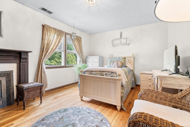 55 Mill Plain Rd Unit 8-1, Danbury, CT 06811 - bedroom with wood finished floors, a textured ceiling, and a fireplace