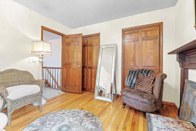 55 Mill Plain Rd Unit 8-1, Danbury, CT 06811 - living area with an upstairs landing, light wood-style floors, and a textured ceiling