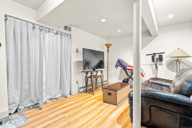 living area with recessed lighting, wood finished floors, and visible vents