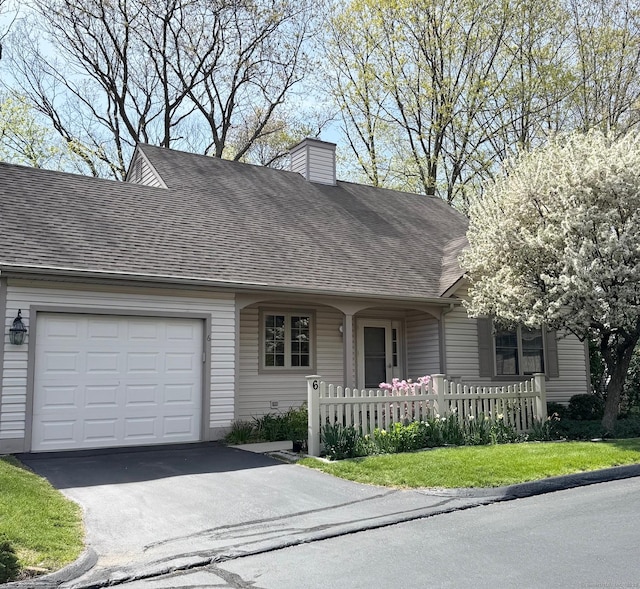 view of front of house featuring fence private yard, aphalt driveway, a chimney, a shingled roof, and an attached garage
