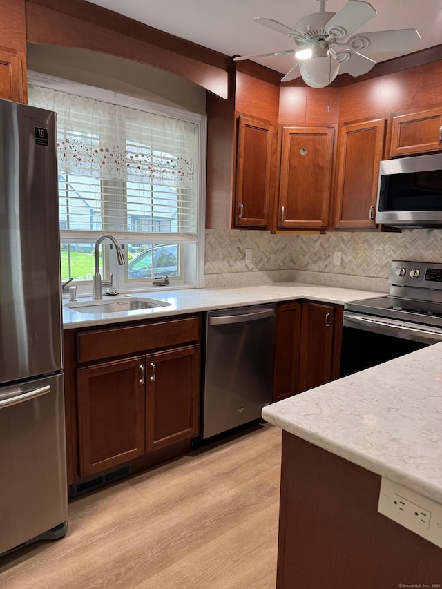 kitchen with a sink, light wood-style floors, light countertops, stainless steel appliances, and visible vents