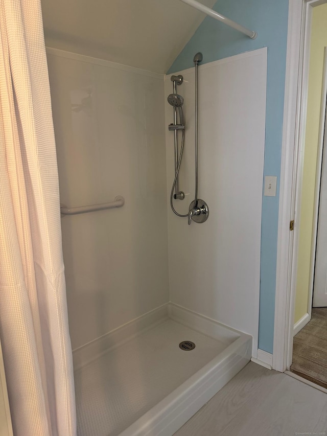 bathroom featuring a shower with shower curtain and vaulted ceiling