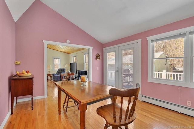 dining area with light wood finished floors, french doors, lofted ceiling, and plenty of natural light