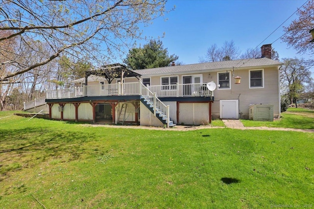 rear view of house featuring a yard, a deck, a chimney, and stairs