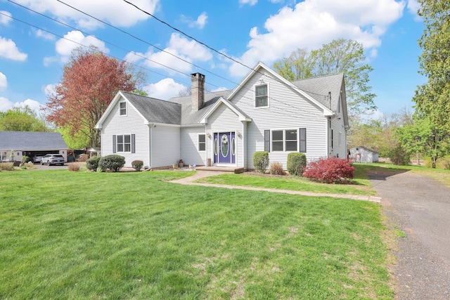 view of front of property with a shingled roof, a chimney, and a front lawn