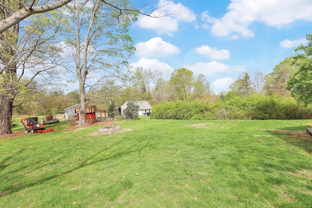 view of yard featuring an outbuilding and a fire pit
