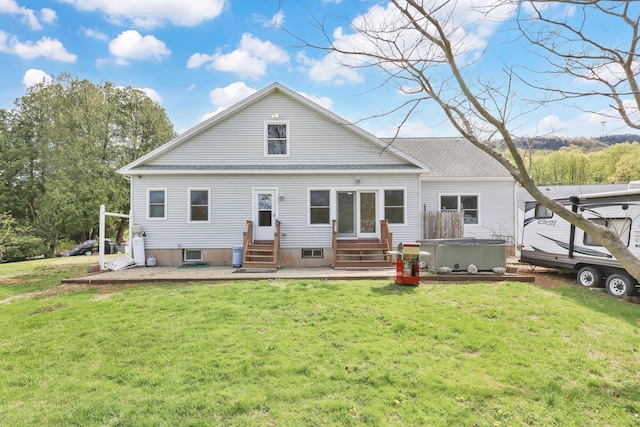 back of property with a hot tub, a yard, and entry steps