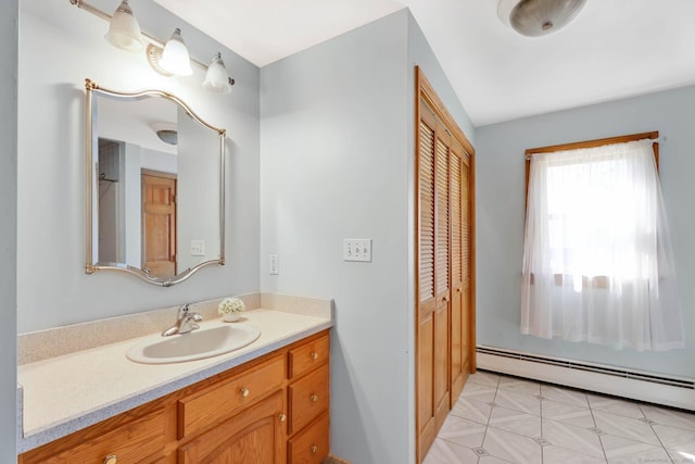 bathroom featuring baseboard heating and vanity