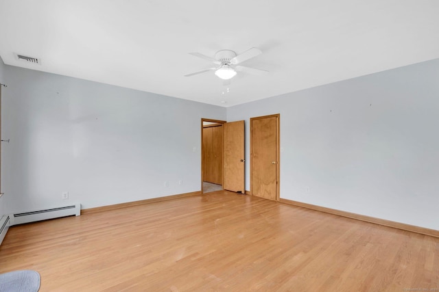 spare room featuring a ceiling fan, visible vents, baseboard heating, baseboards, and light wood-style flooring
