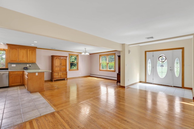interior space with visible vents, baseboard heating, light wood-type flooring, light countertops, and a notable chandelier