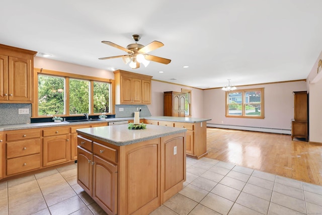 kitchen featuring a kitchen island, tasteful backsplash, a sink, a baseboard heating unit, and a peninsula