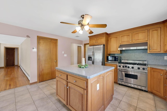 kitchen featuring a kitchen island, ceiling fan, baseboard heating, under cabinet range hood, and appliances with stainless steel finishes