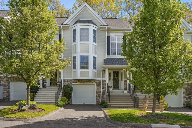 1803 Revere Rd, Danbury, CT 06811 - view of front of home featuring stairway, roof with shingles, stone siding, and aphalt driveway