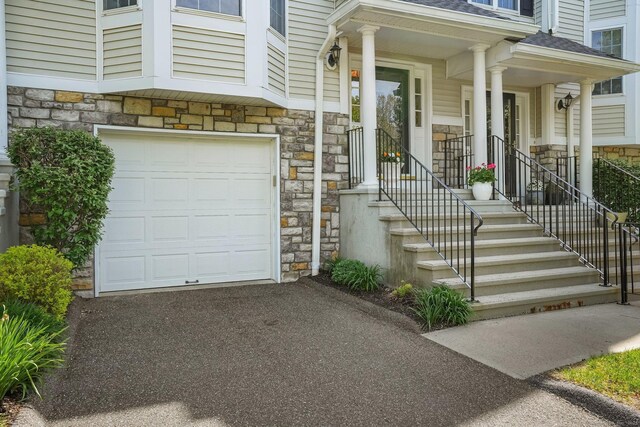 1803 Revere Rd, Danbury, CT 06811 - view of exterior entry featuring a garage, driveway, and stone siding