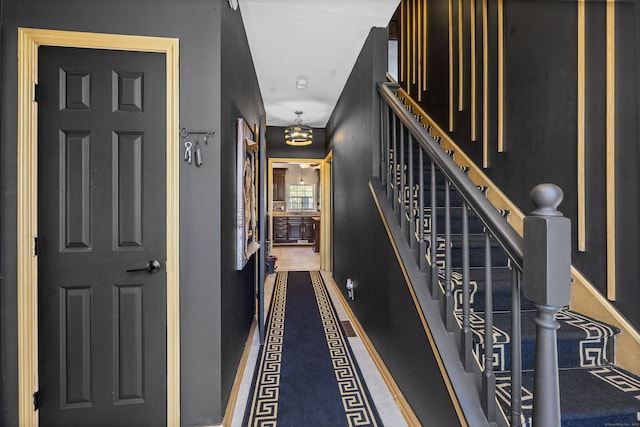 corridor featuring stairs and baseboards