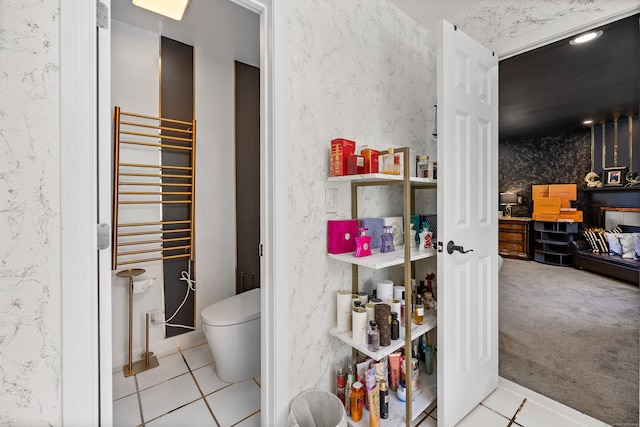 bathroom with radiator heating unit, tile patterned flooring, and toilet