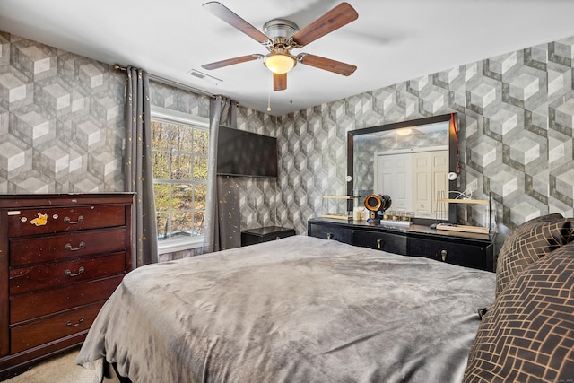 bedroom featuring visible vents, ceiling fan, and wallpapered walls