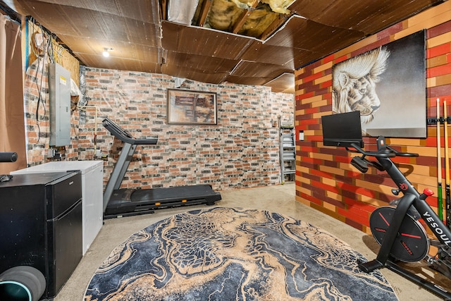 workout area featuring brick wall and electric panel