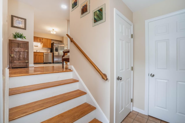 stairway featuring tile patterned flooring and baseboards