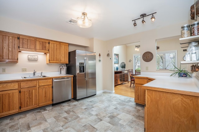 kitchen featuring stone finish flooring, visible vents, appliances with stainless steel finishes, a sink, and light countertops