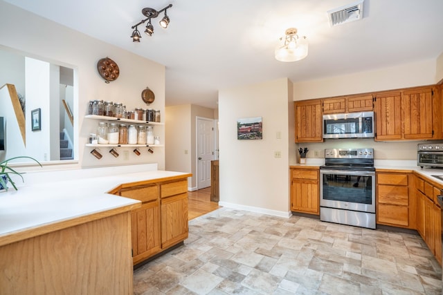 kitchen featuring light countertops, stainless steel appliances, baseboards, stone finish flooring, and visible vents