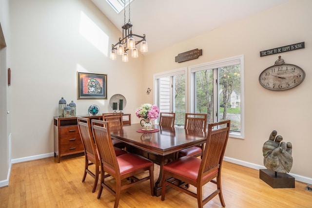 dining space featuring baseboards, light wood finished floors, a notable chandelier, and visible vents