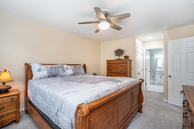 bedroom with baseboards, light carpet, a ceiling fan, and connected bathroom