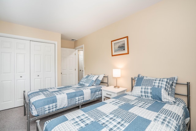 carpeted bedroom with visible vents and a closet