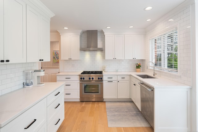 1 Maple St Unit 1, New Canaan, CT 06840 - kitchen with a sink, stainless steel appliances, wall chimney exhaust hood, white cabinetry, and decorative backsplash