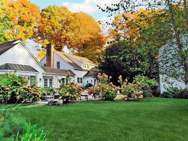 721 Ridgefield Rd, Wilton, CT 06897 - back of house featuring a lawn, a chimney, and a standing seam roof