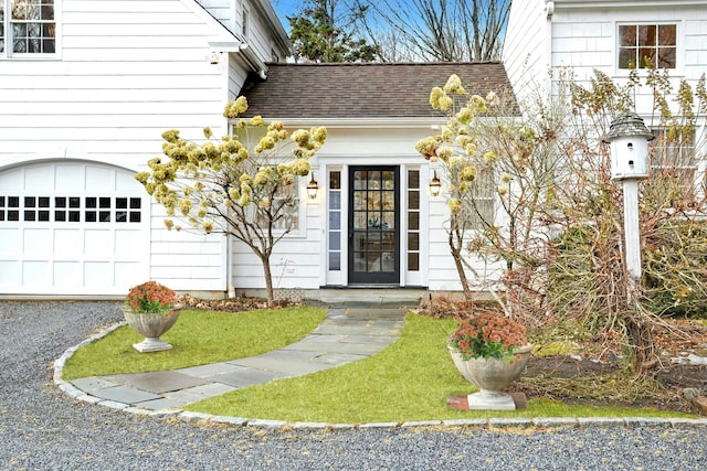 721 Ridgefield Rd, Wilton, CT 06897 - view of exterior entry featuring roof with shingles, a garage, and gravel driveway