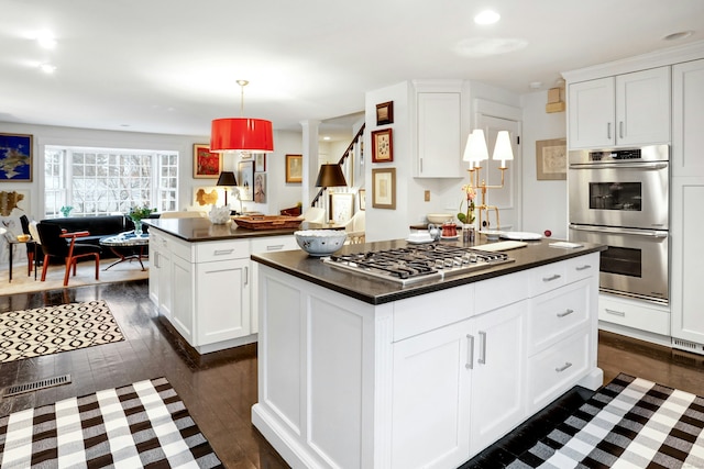 721 Ridgefield Rd, Wilton, CT 06897 - kitchen featuring appliances with stainless steel finishes, a kitchen island, dark countertops, dark wood finished floors, and recessed lighting
