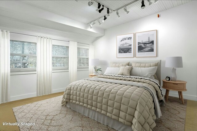 bedroom with track lighting and baseboards