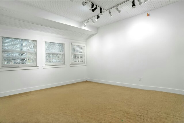 unfurnished room featuring track lighting and baseboards