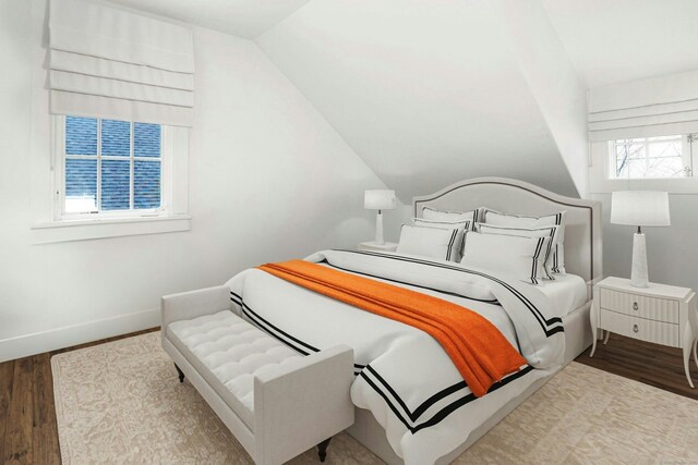 bedroom with baseboards, vaulted ceiling, and wood finished floors