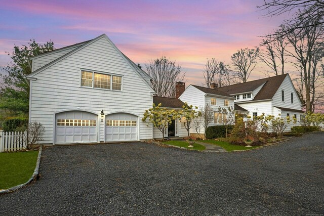view of front facade with a garage, fence, and driveway
