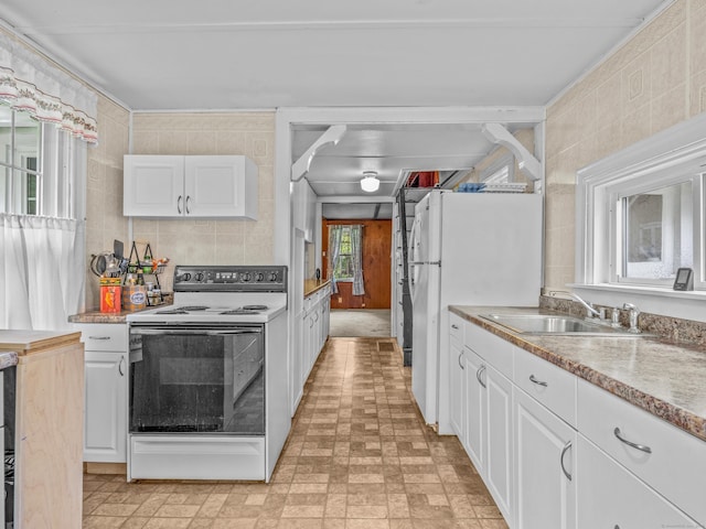 kitchen with white appliances, a sink, white cabinets, and brick patterned floors