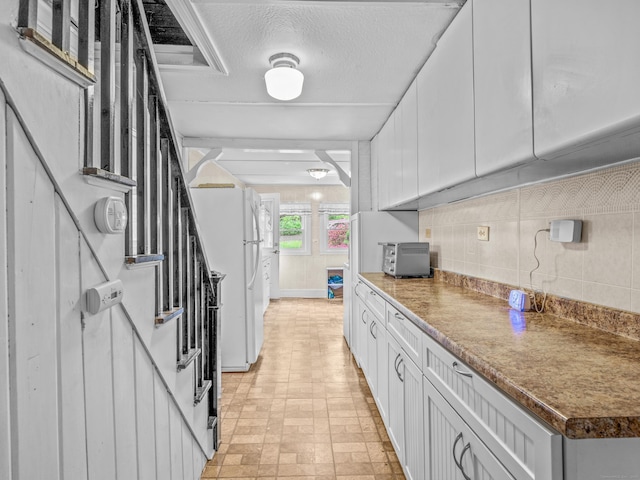 kitchen with backsplash and white cabinetry